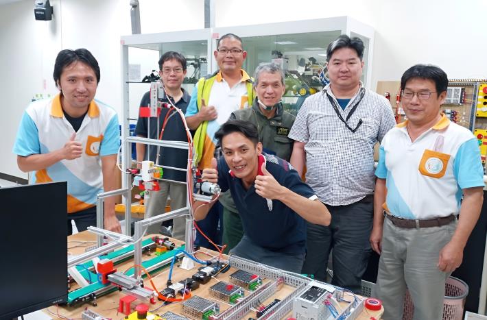 資深傳統機械技師阿鍾 (左3)參加北分署五股職業訓練場智動化與機械手臂班訓練實況_Instructions for literal