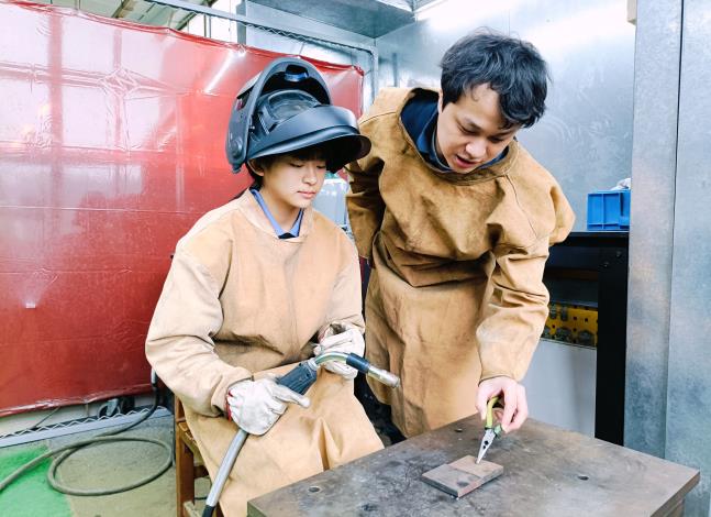 工業機械職類選手羽彤(左)，在北分署訓練師(右)指導下勇闖全國賽。圖為訓練師指導選手張羽彤半自動電銲_Instructions for literal