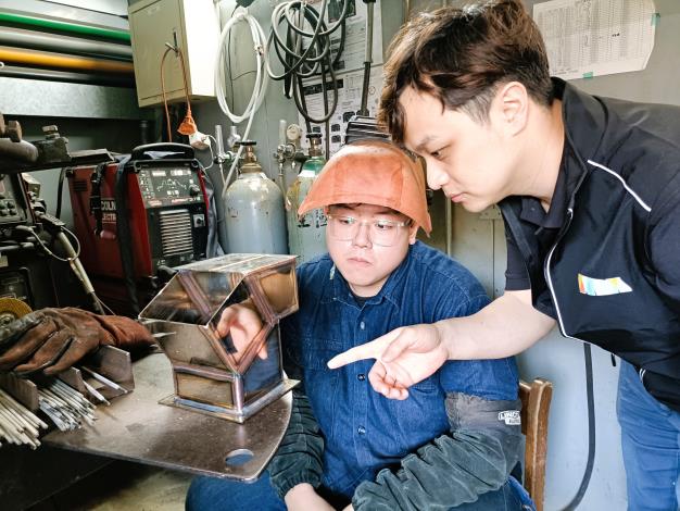 銲接職類選手劉軒瑋(左)在北分署訓練師(右)指導下精進技術，成功晉級第二階段的國手選拔。_Instructions for literal