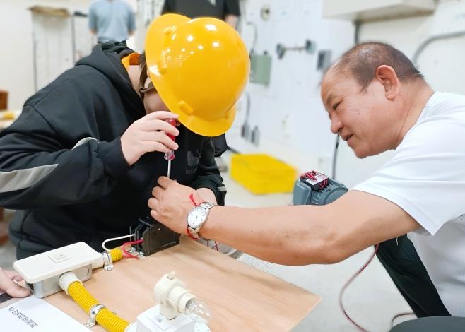 北分署宜蘭職訓場水電職類訓練師陳枝洋(右)指導未就學未就業少年實作簡易電路配線，從手作中產生對技能的興趣。_Instructions for literal