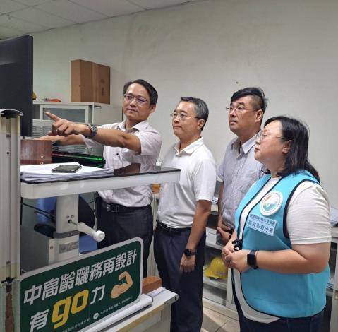 照片01.企業和高分署合作職務再設計服務，以合適站姿高度的小型升降桌，幫助中高齡員工(左1)改變工作姿勢，避免久坐以減少頸椎負擔。_Instructions for literal